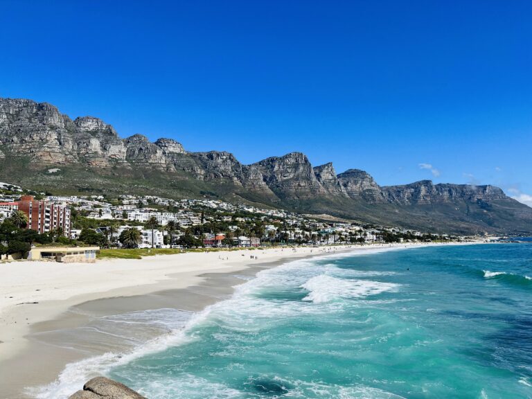 beautiful blue ocean, white sandy beach, as well as the neighbourhood nestled between the ocean and the mountains, one of the most popular Cape Town beaches