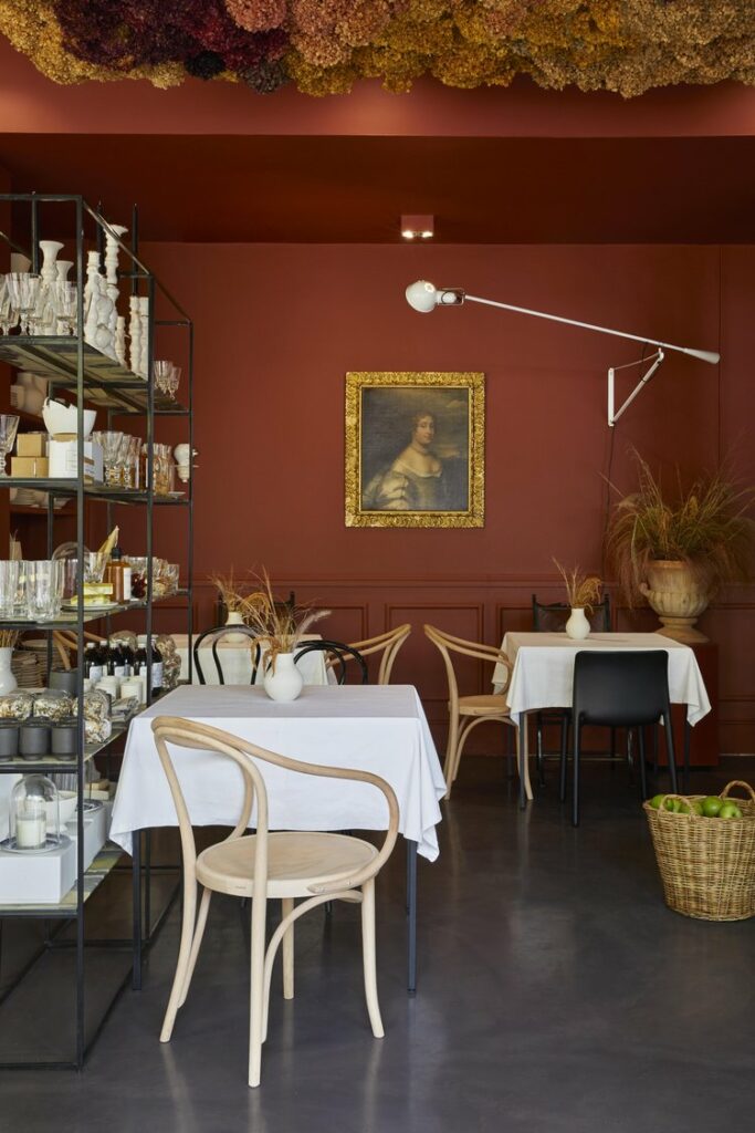 Cosy space with small tables, dark floors and maroon orange walls, a stylish place for breakfast Cape Town has to offer