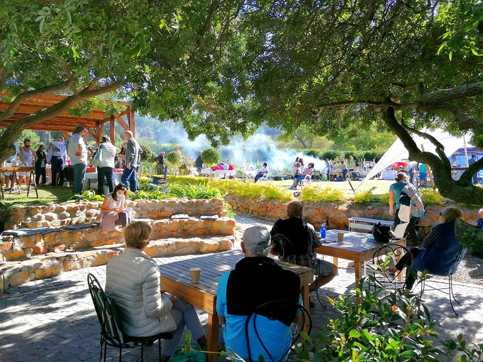 a bustling market with people picnicing and braaing on the lawns, while others look on from the shaded outdoor seating, a lot on offer at this Hout Bay market