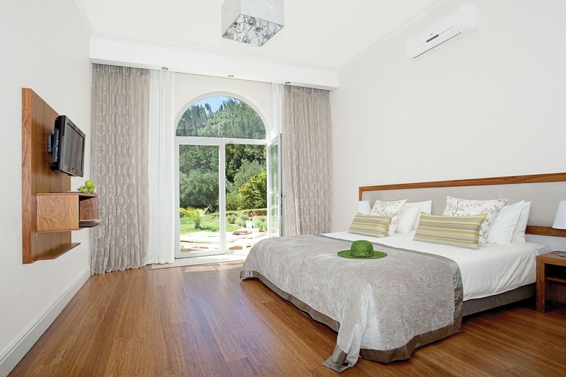 beautiful room at this Paarl accommodation, wooden floors and furnishings contrast the white interior, a breathtaking pine forest can be seen through the double glass doors.