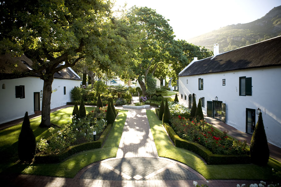 The courtyard of this Paarl accommodation, a brick path runs through the beautiful gardens, nestled between two cape dutch architecture buildings