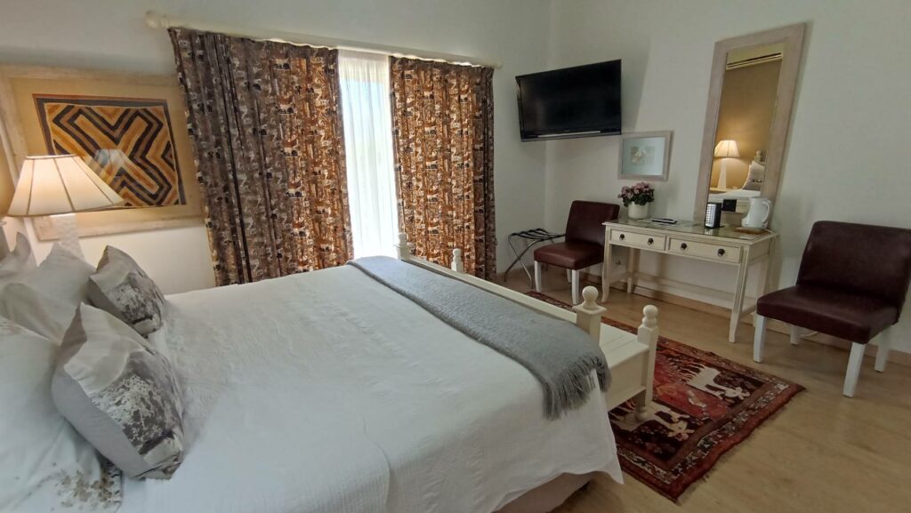 A well furnished and beautifully decorated room at this Paarl accommodation, features a double bed, vanity desk, and two chairs