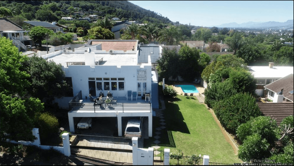 This Paarl accommodation is situated in a large white house, with green lawns and a pool