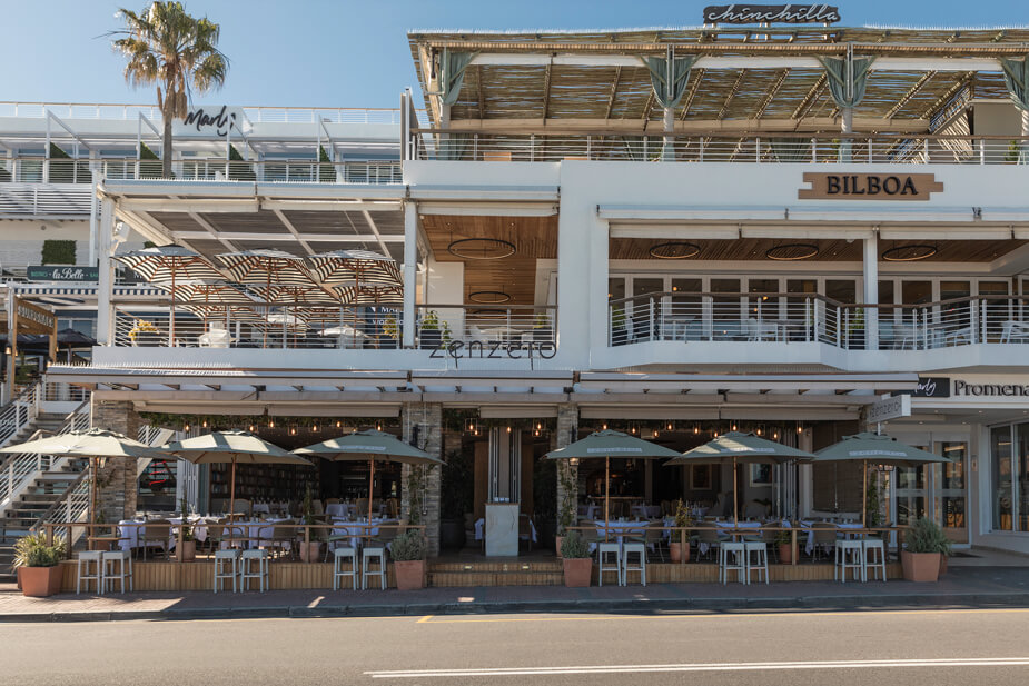 The front entrance of this restaurant in Camps Bay with outdoor seating next to is