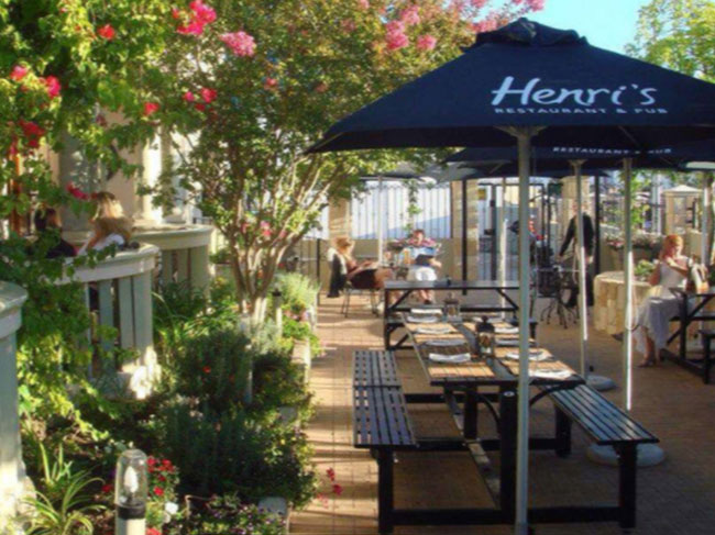 The outdoor seating of this Somerset West restaurant, with picnic tables and umbrellas, and stunning gardens