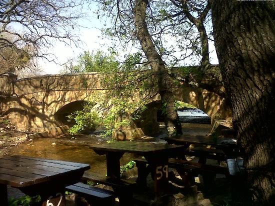 Outdoor seating overlooking the old bridge that this Somerset West restaurant is named for