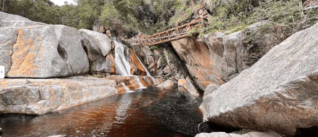 A pool of water surrounded by rocks, just one example of the stunning scenery offered by this trail for backpacking Garden Route